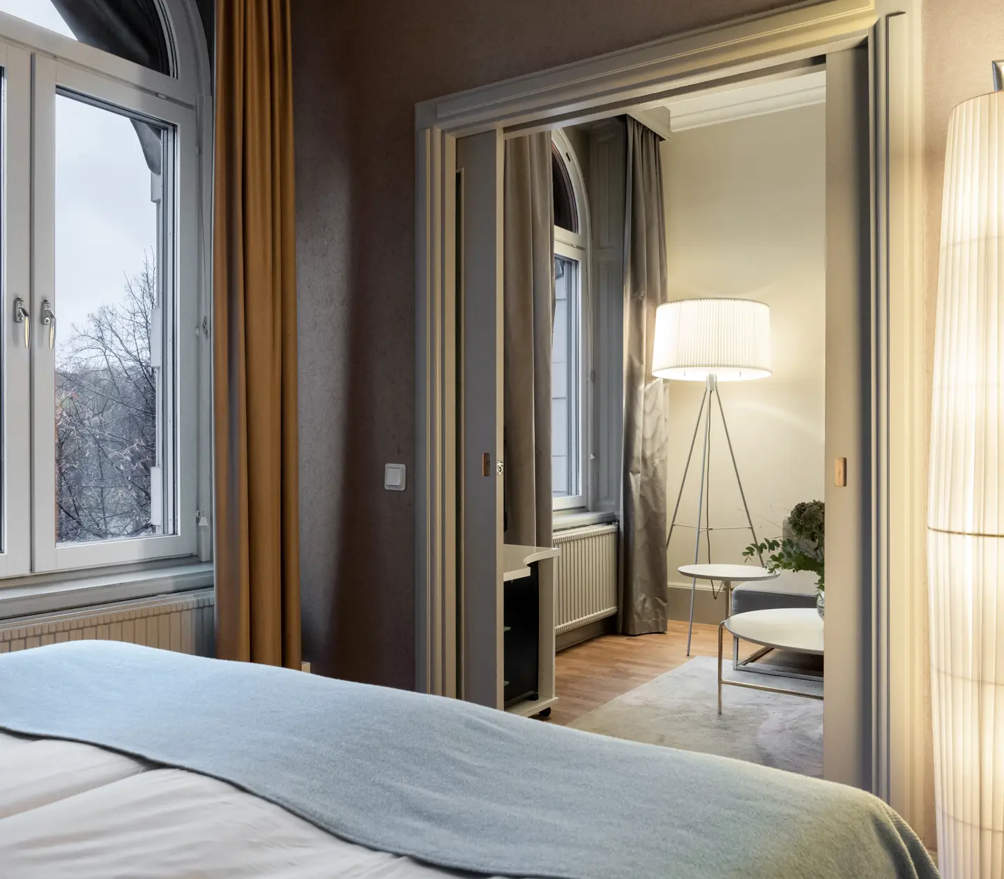Cozy hotel room with double bed, window and door to living room