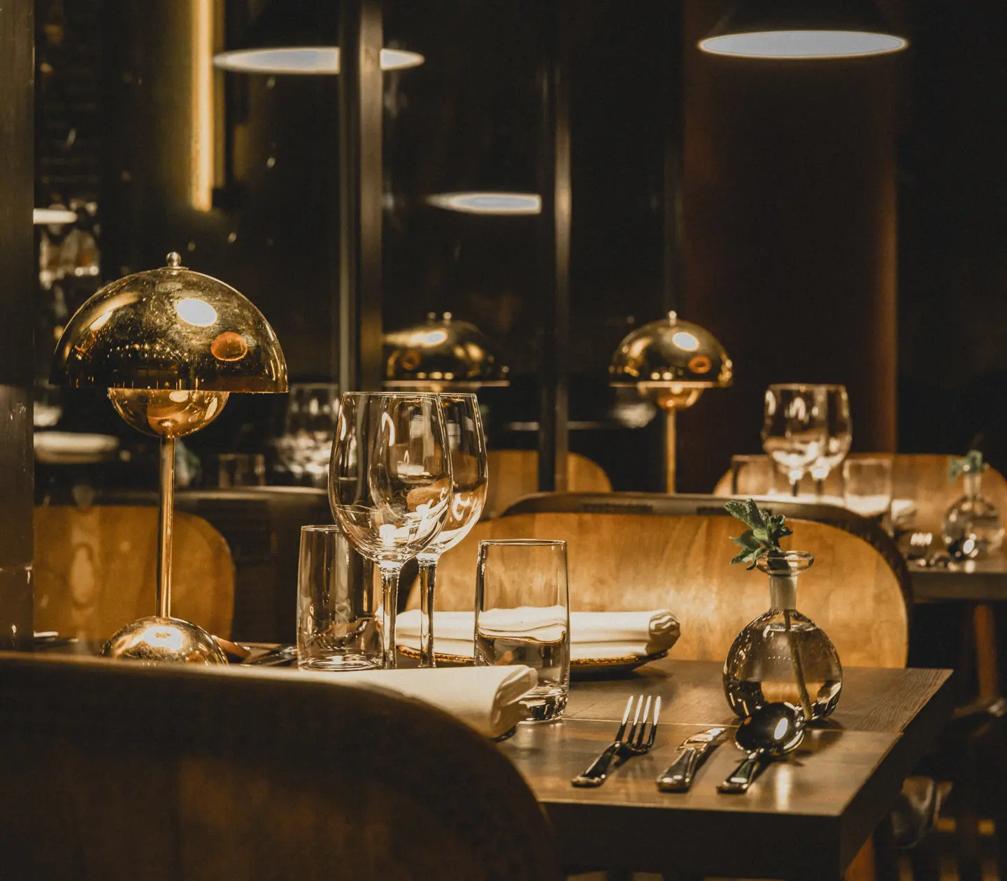 Cosy restaurant environment with set tables and a small table lamp.