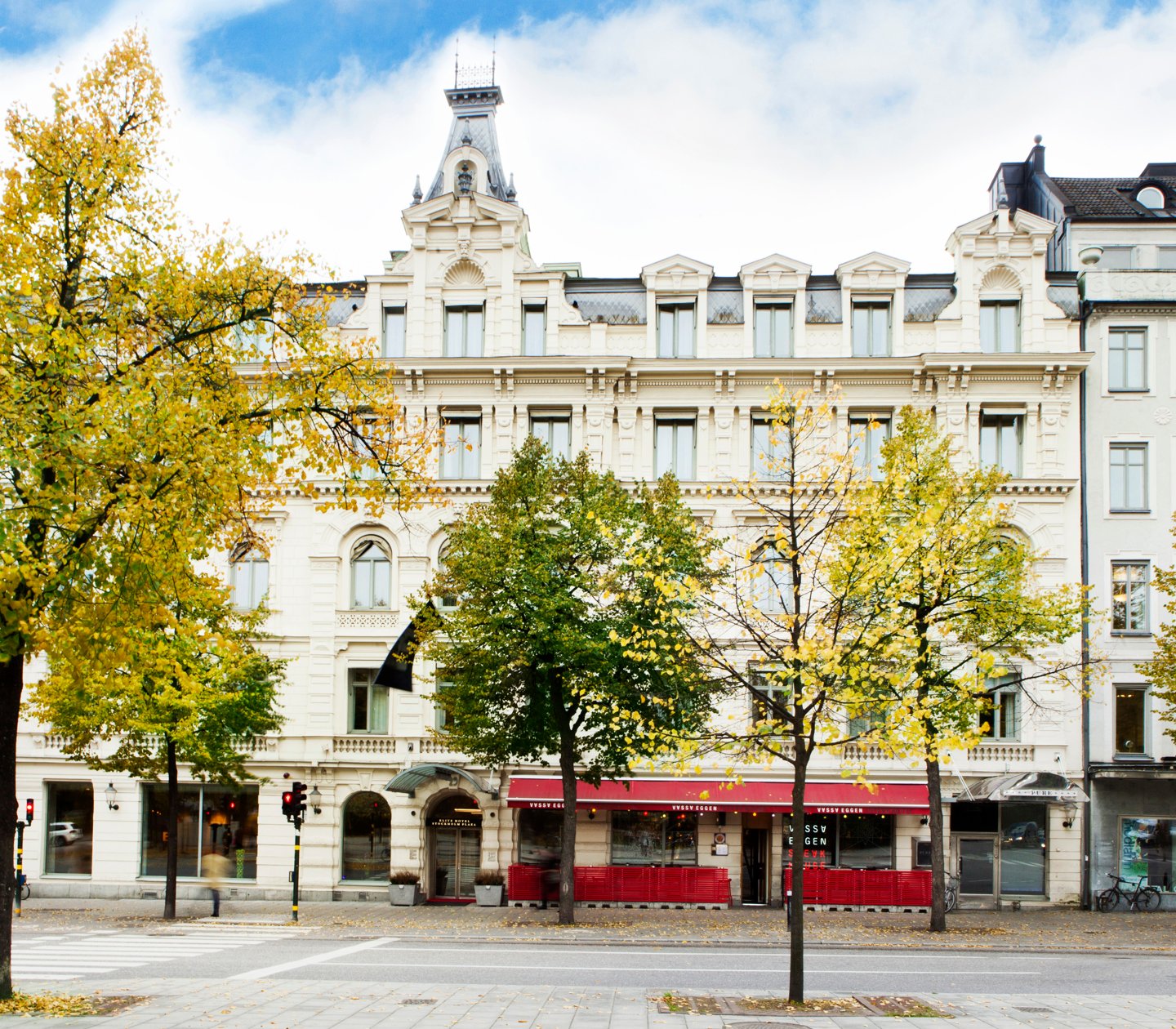 Elite Hotel Stockholm Plazas fasad med grönskande träd utanför 