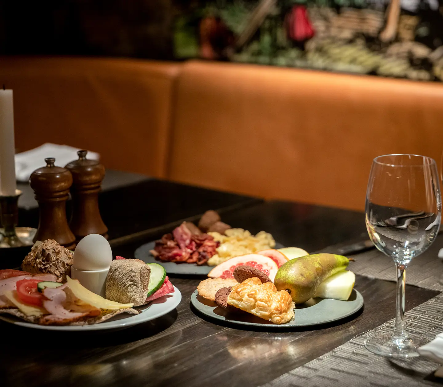 Restaurant table with breakfast plates laid out with eggs, sandwiches and fruit