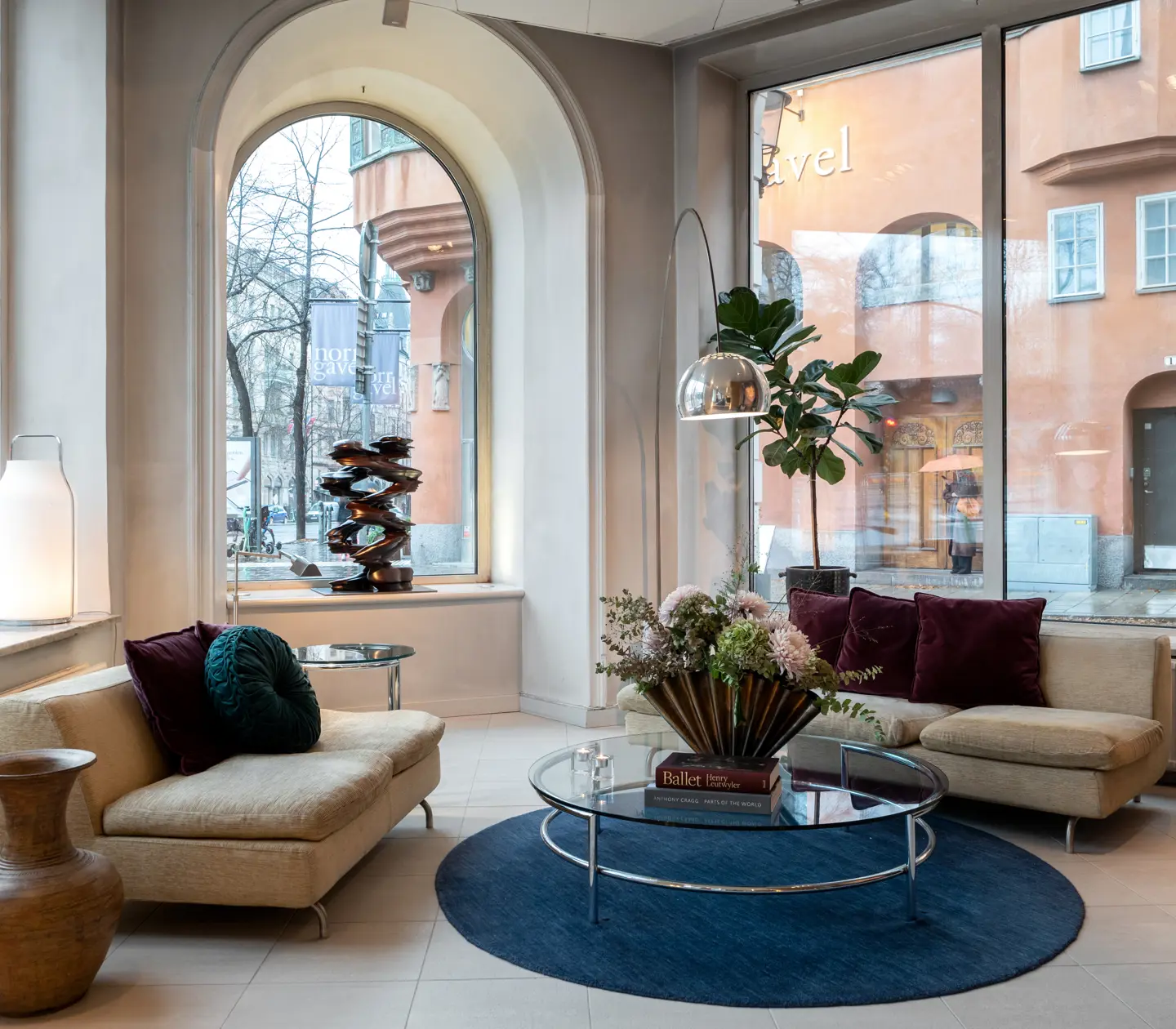 Bright hotel lobby with sofas, table, bouquet and large windows with lots of light