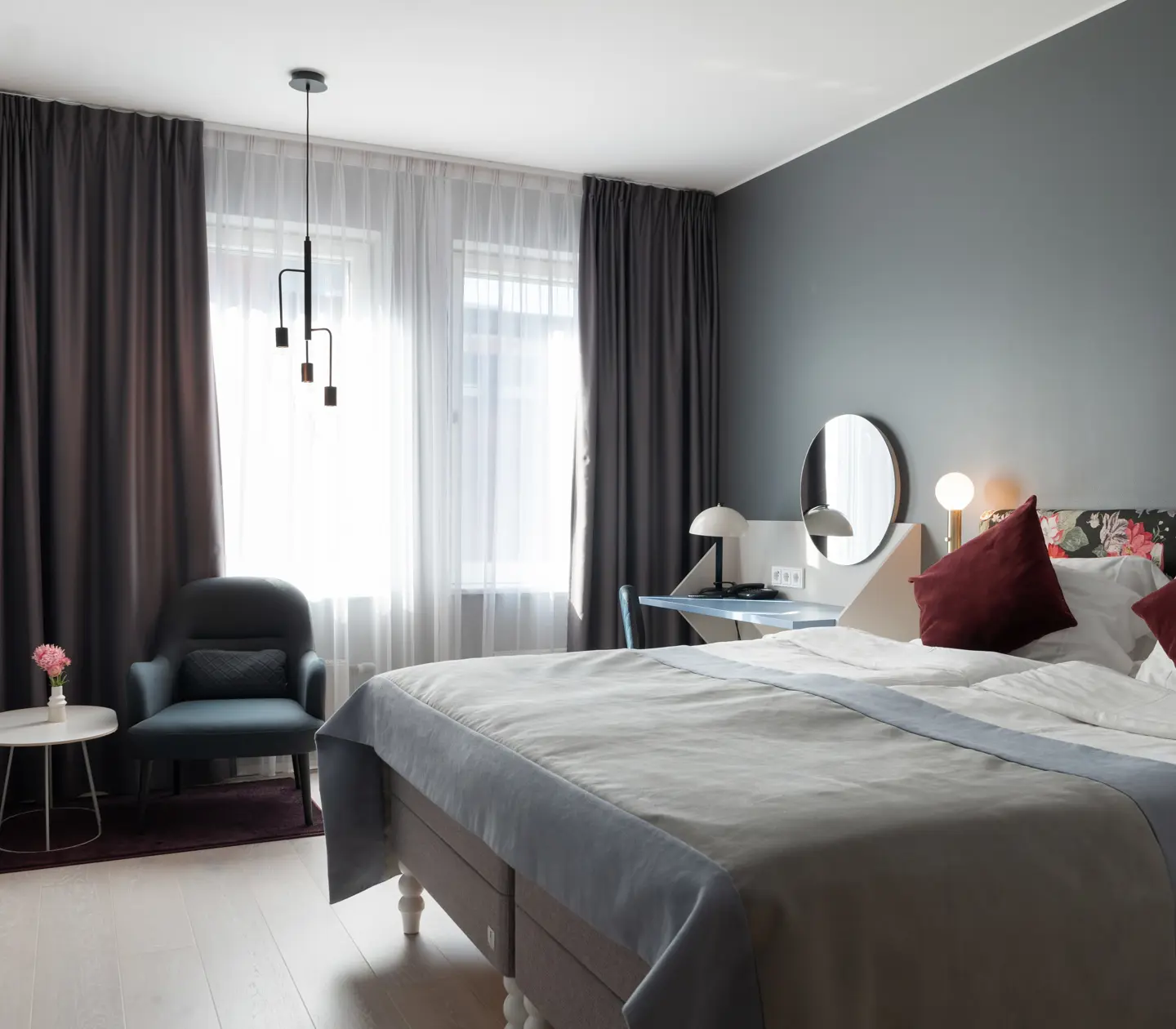 Double bed, armchair and TV in hotel room