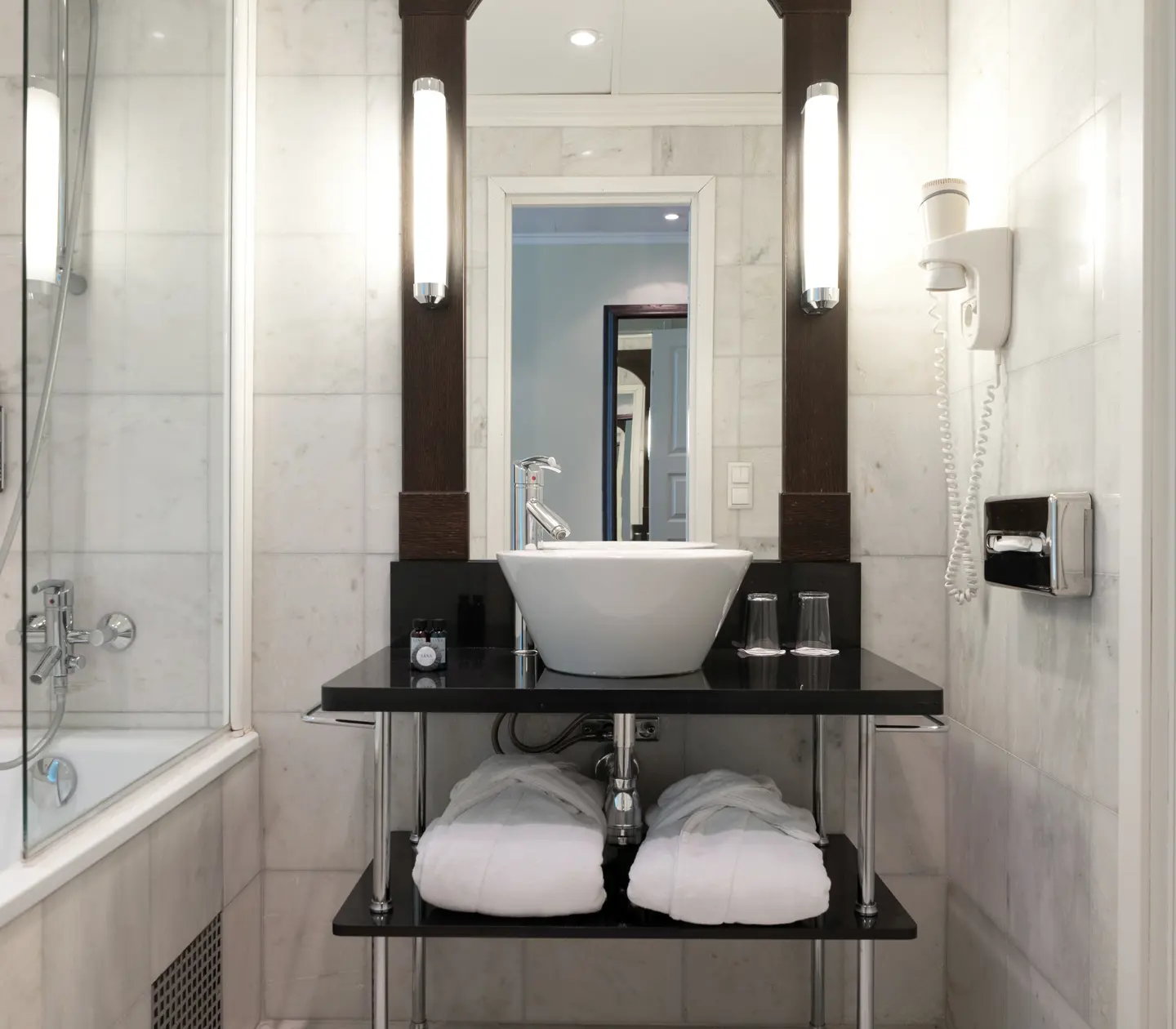 Bath and sink with wooden chest of drawers