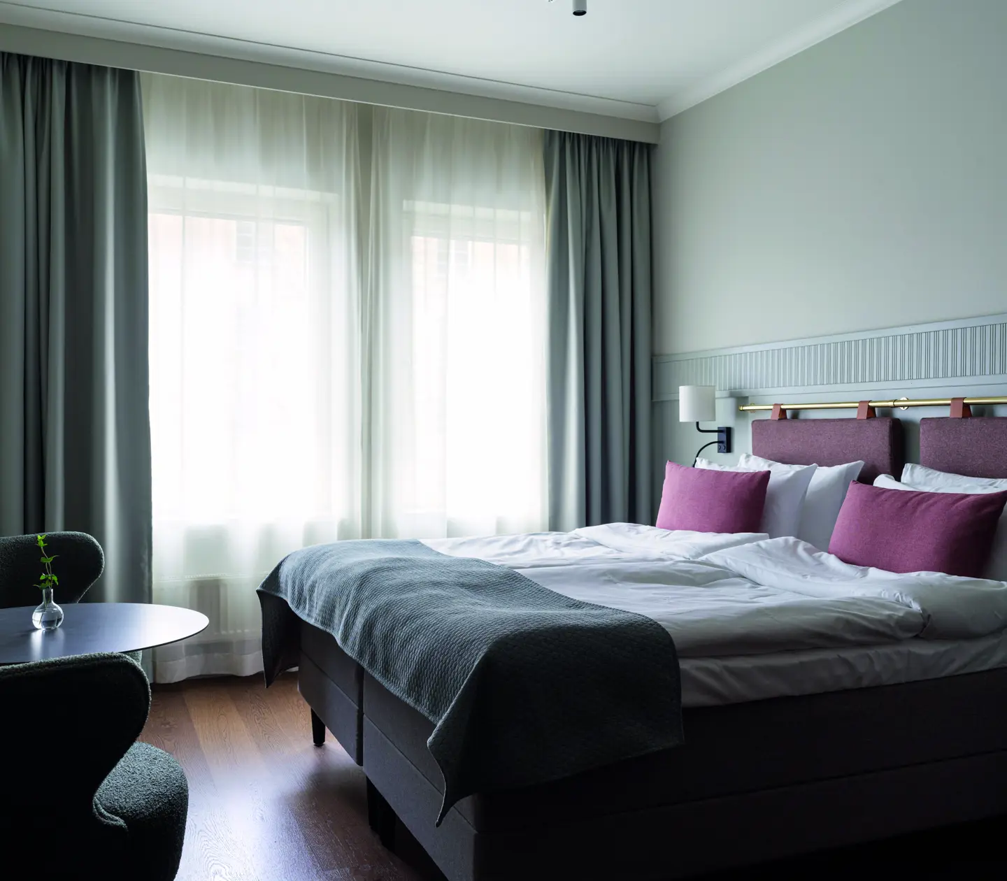A room with a double bed and pink pillows