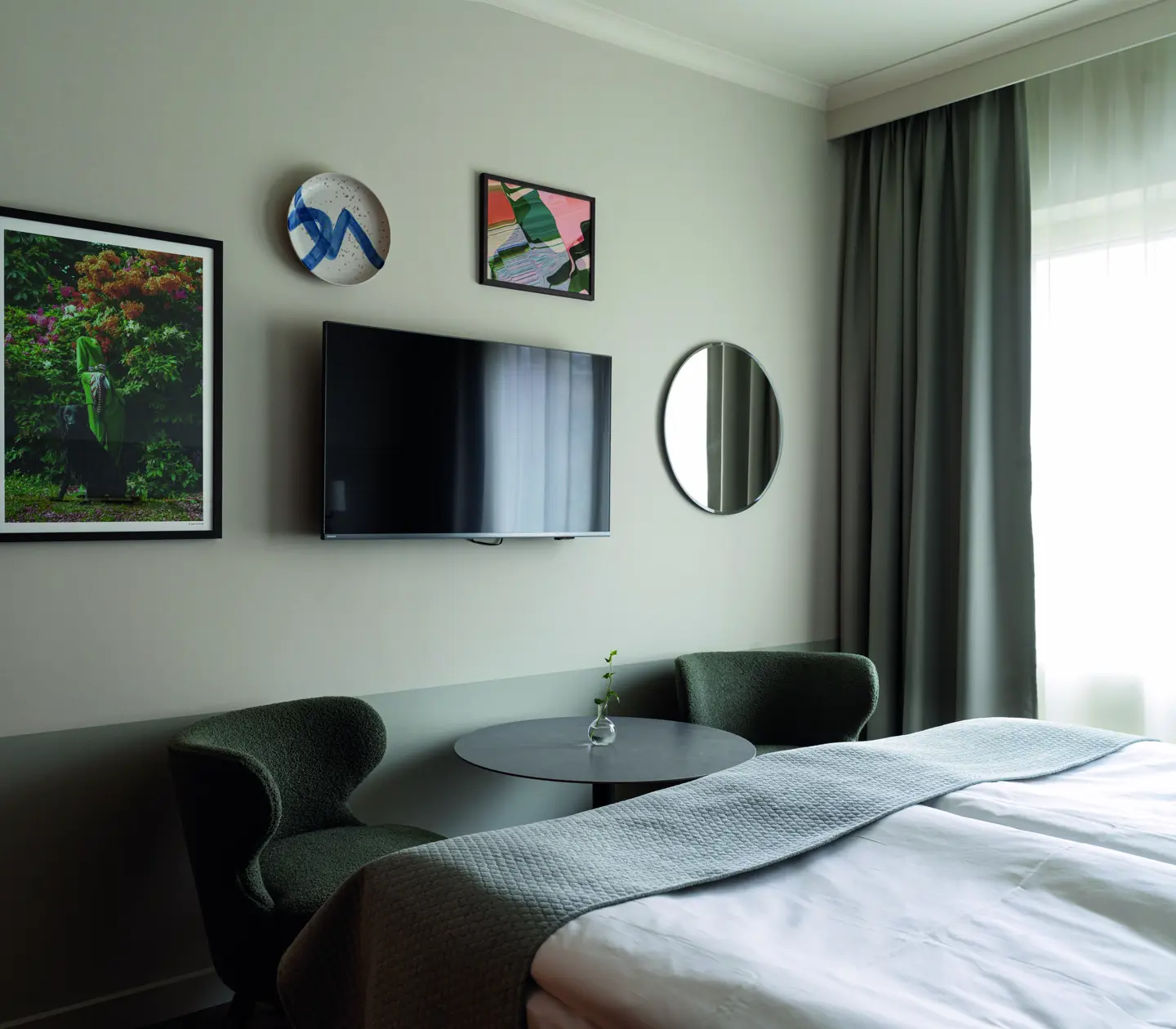 A double bed with tv and art on the wall