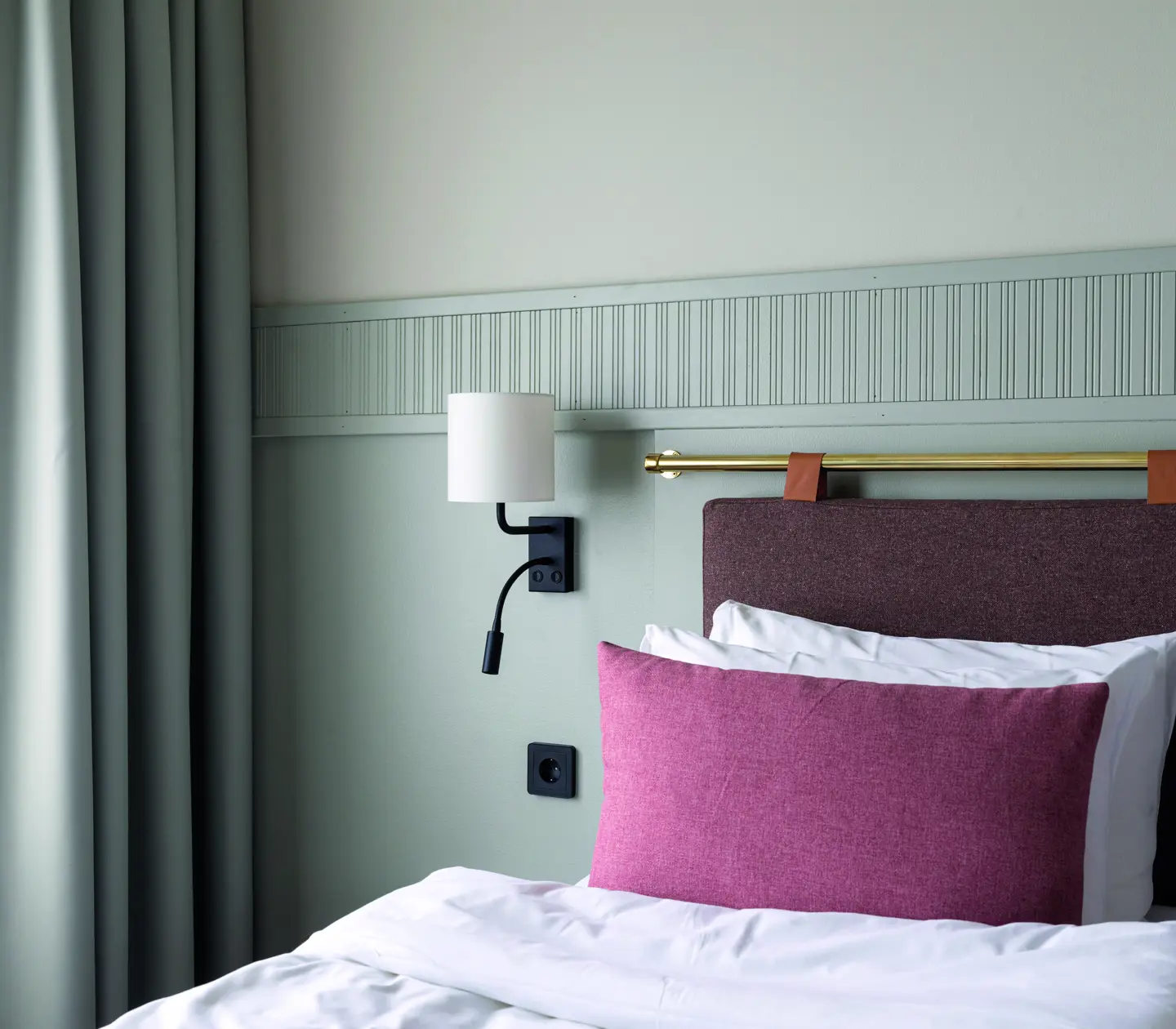 A bed with a pink pillow