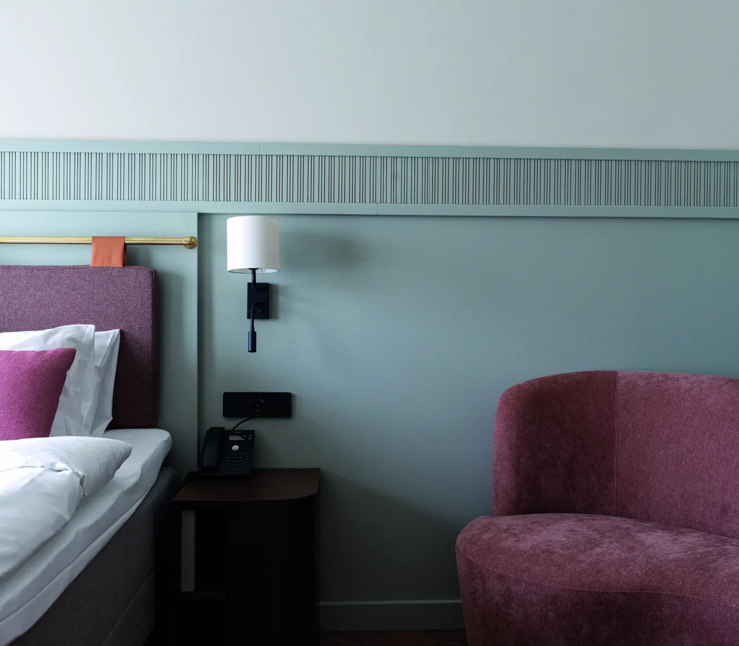 Bed with pink pillow and a pink armchair