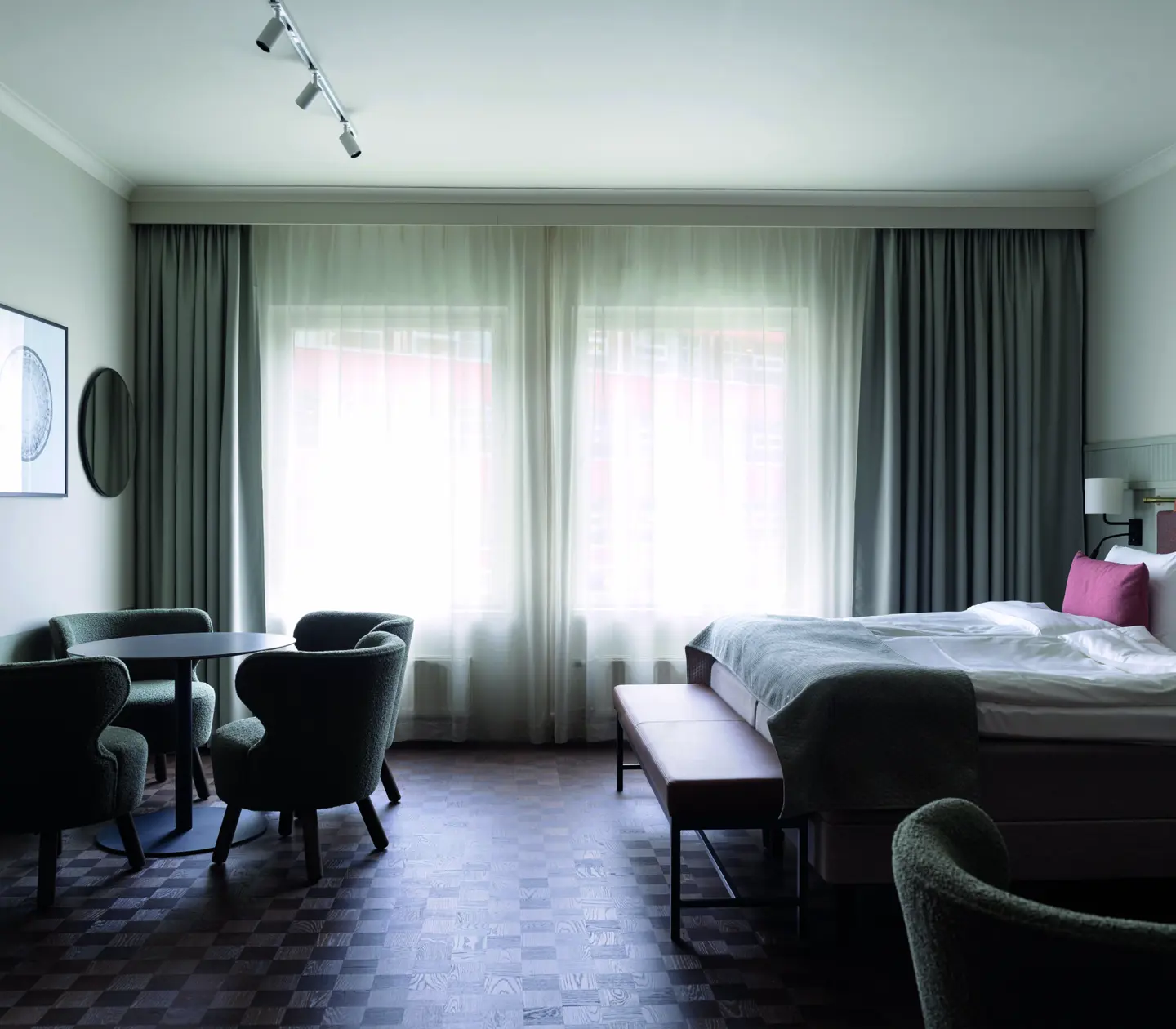 A large room with a double bed and a seating area