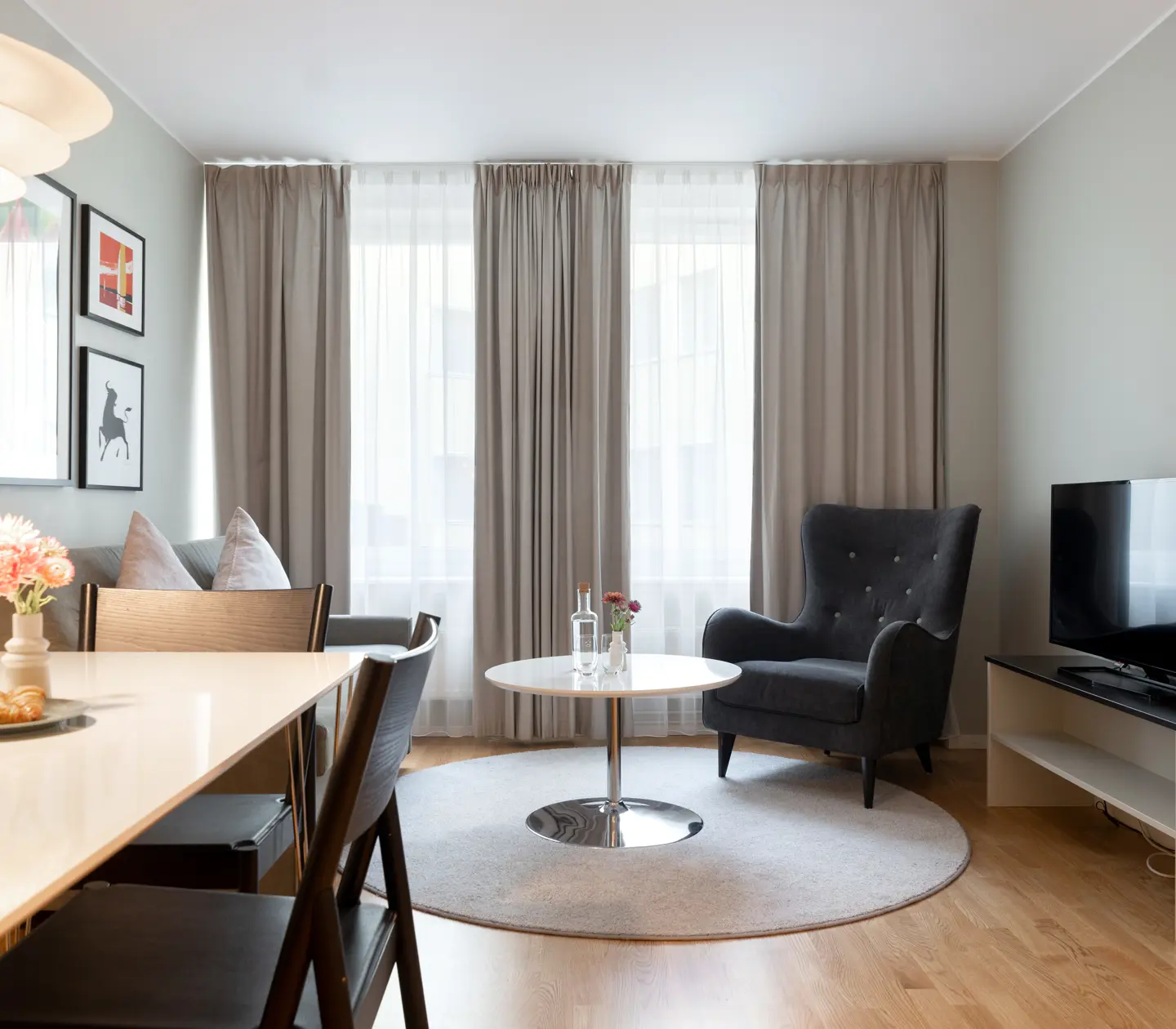 Table with chairs and lounge area with sofa and TV