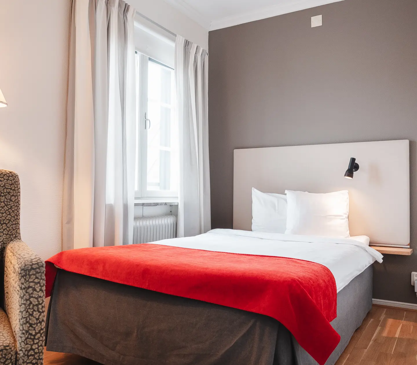 Cozy hotel room with bed, armchair and window
