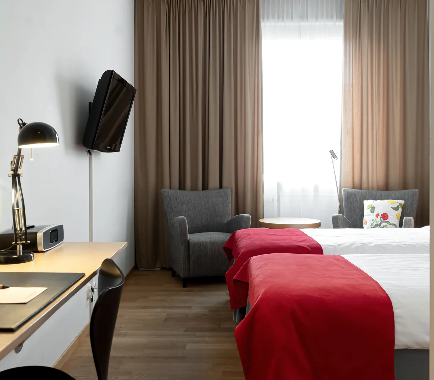 Cozy hotel room with beds, armchairs and desk