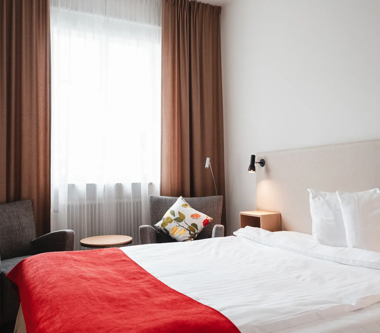 Cozy hotel room with bed, armchair and window