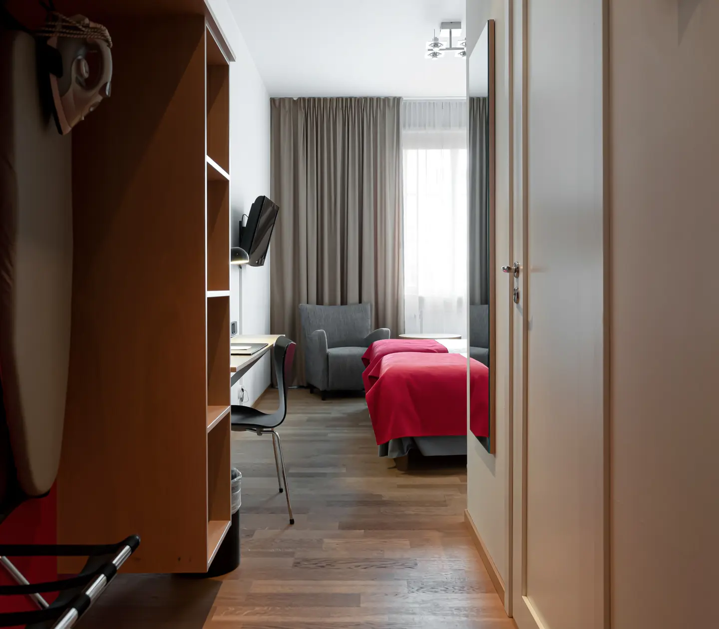 Hotel room with desk, armchair and TV