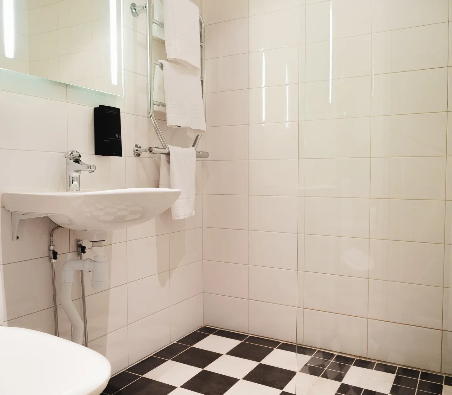 White and black bathroom with toilet, sink and towels