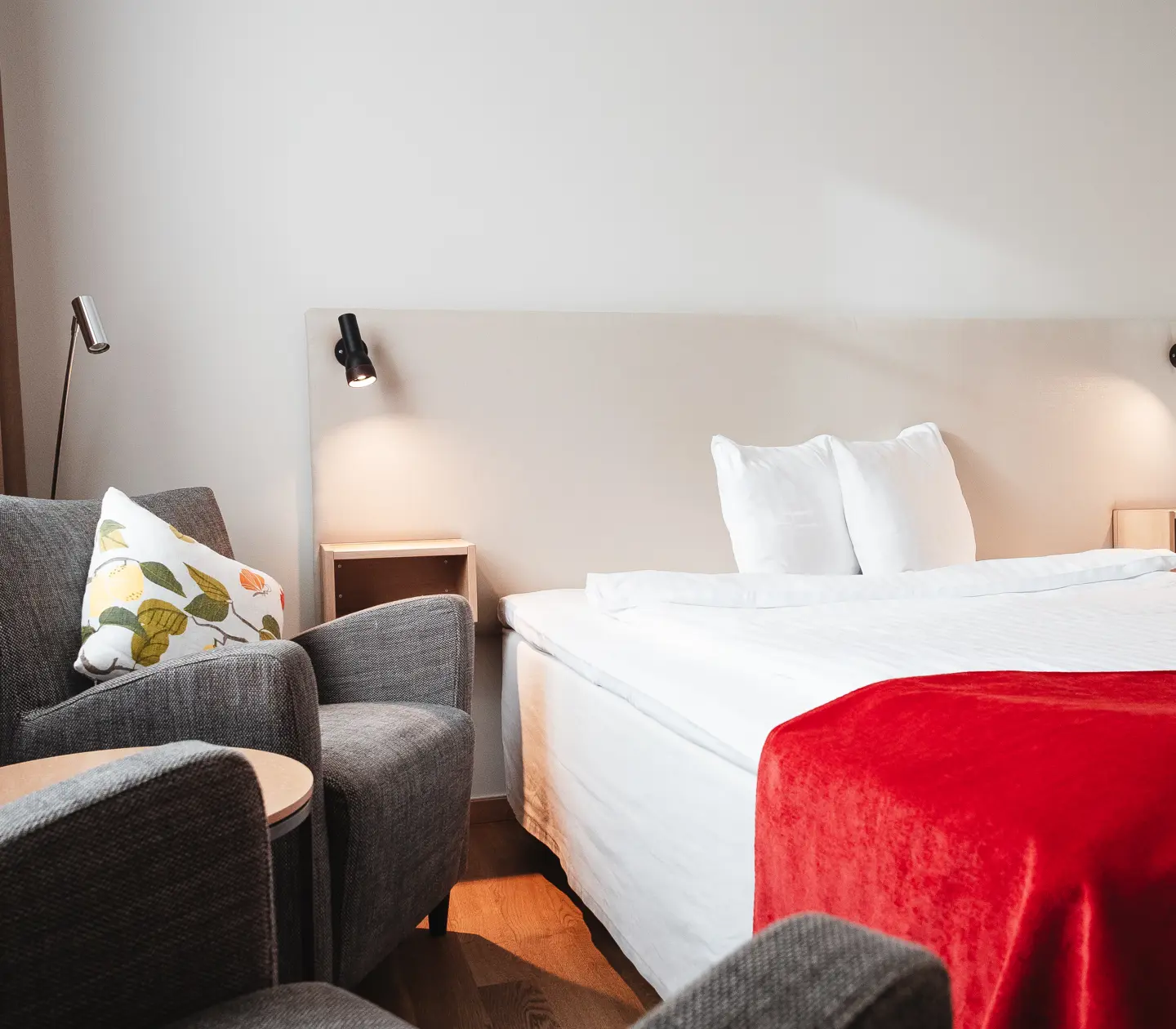 Cozy hotel room with bed, armchairs and bedside lamps