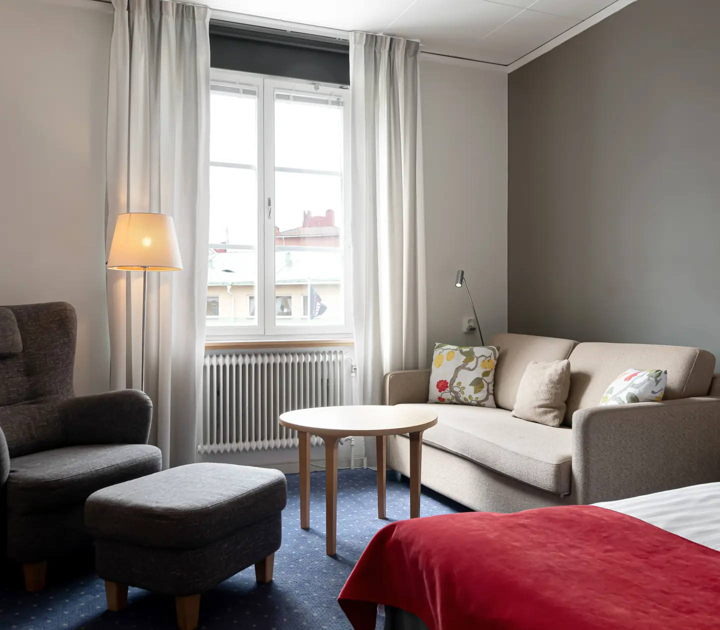 Cozy hotel room with bed, sitting area and window
