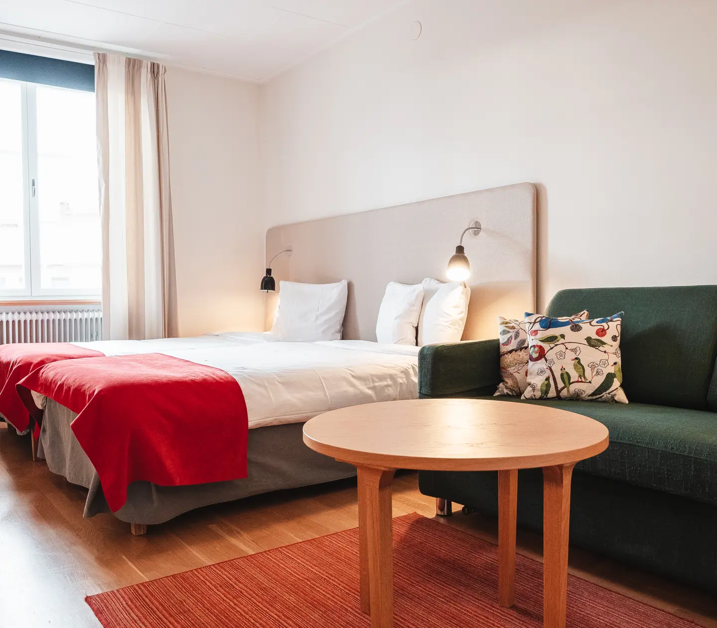 Cozy hotel room with bed, sofa and window