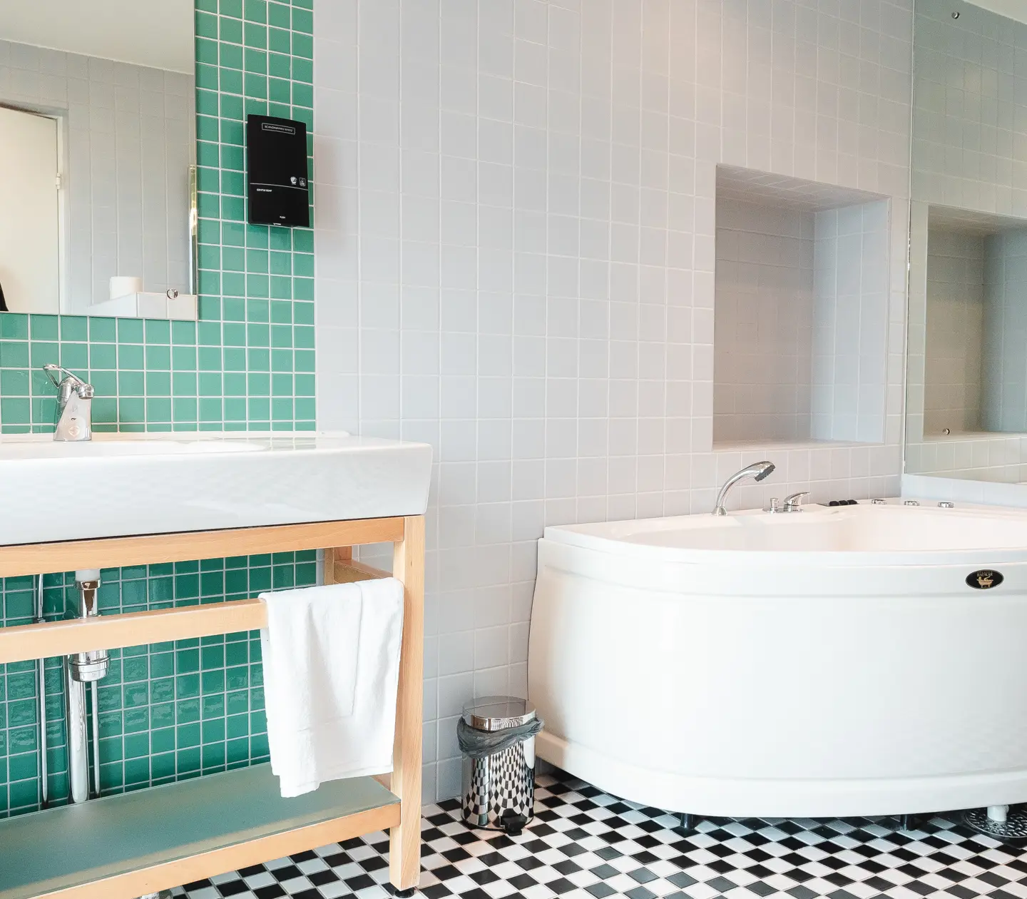 White and green bathroom with bathtub, sink and mirror