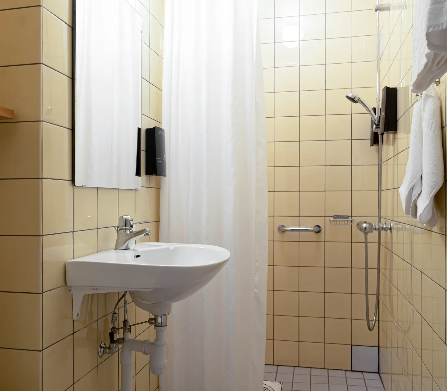 Yellow bathroom with shower, sink and mirror