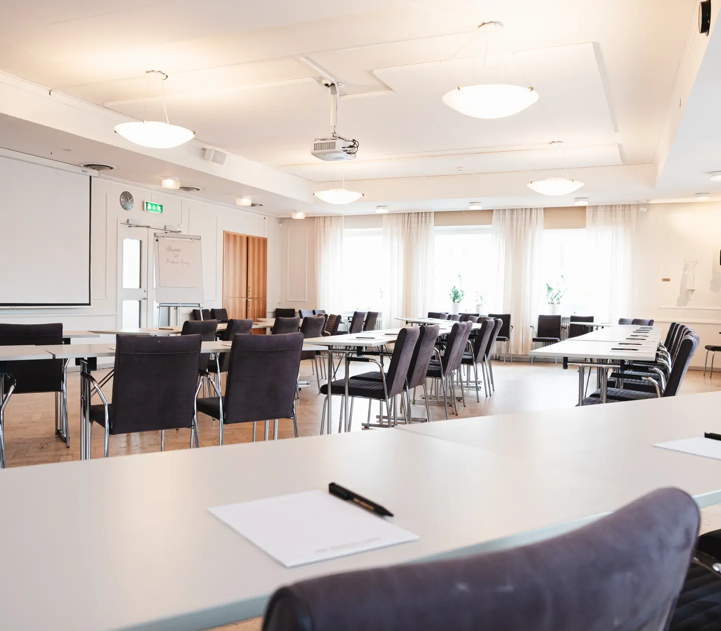 Conference room with many seats, ceiling lights and projector