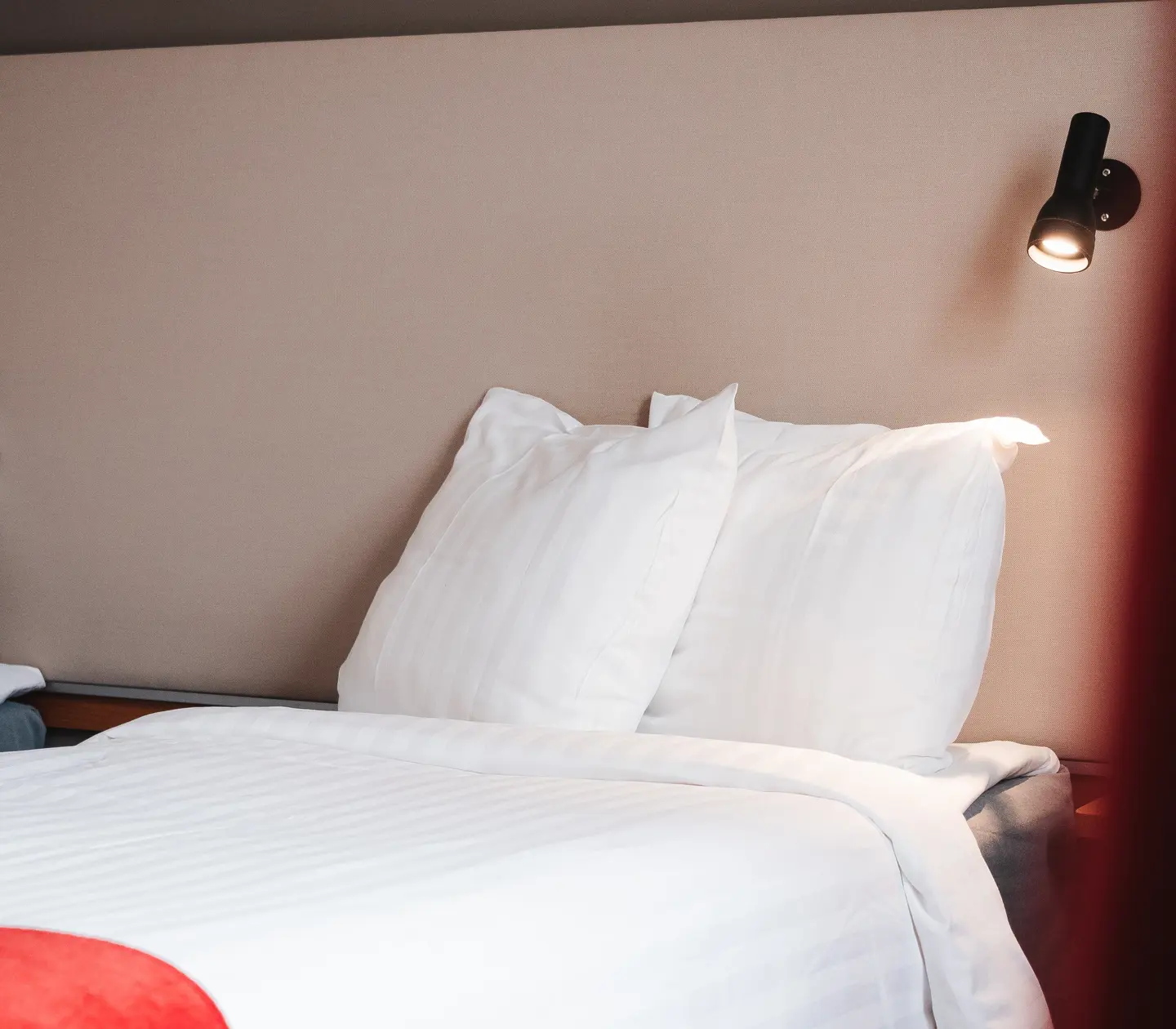 Close-up of bed, pillows and bedside lamp