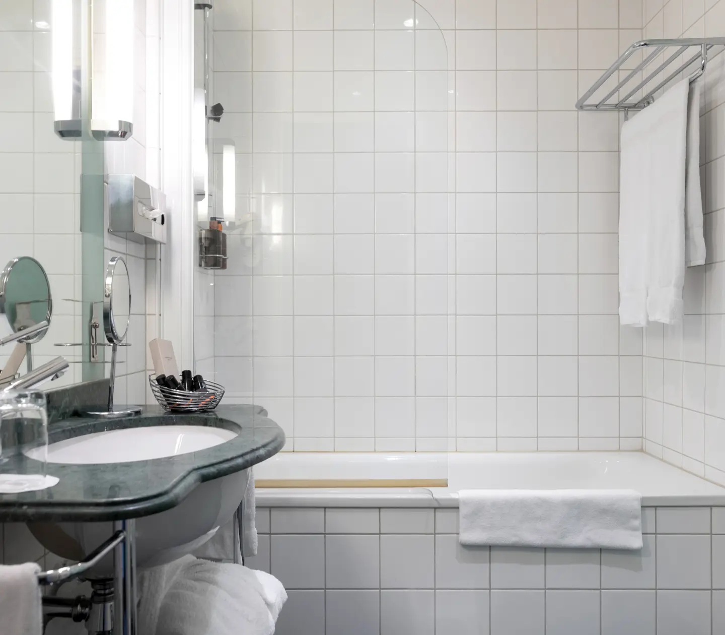 Bright bathroom with bathtub, green sink and towels
