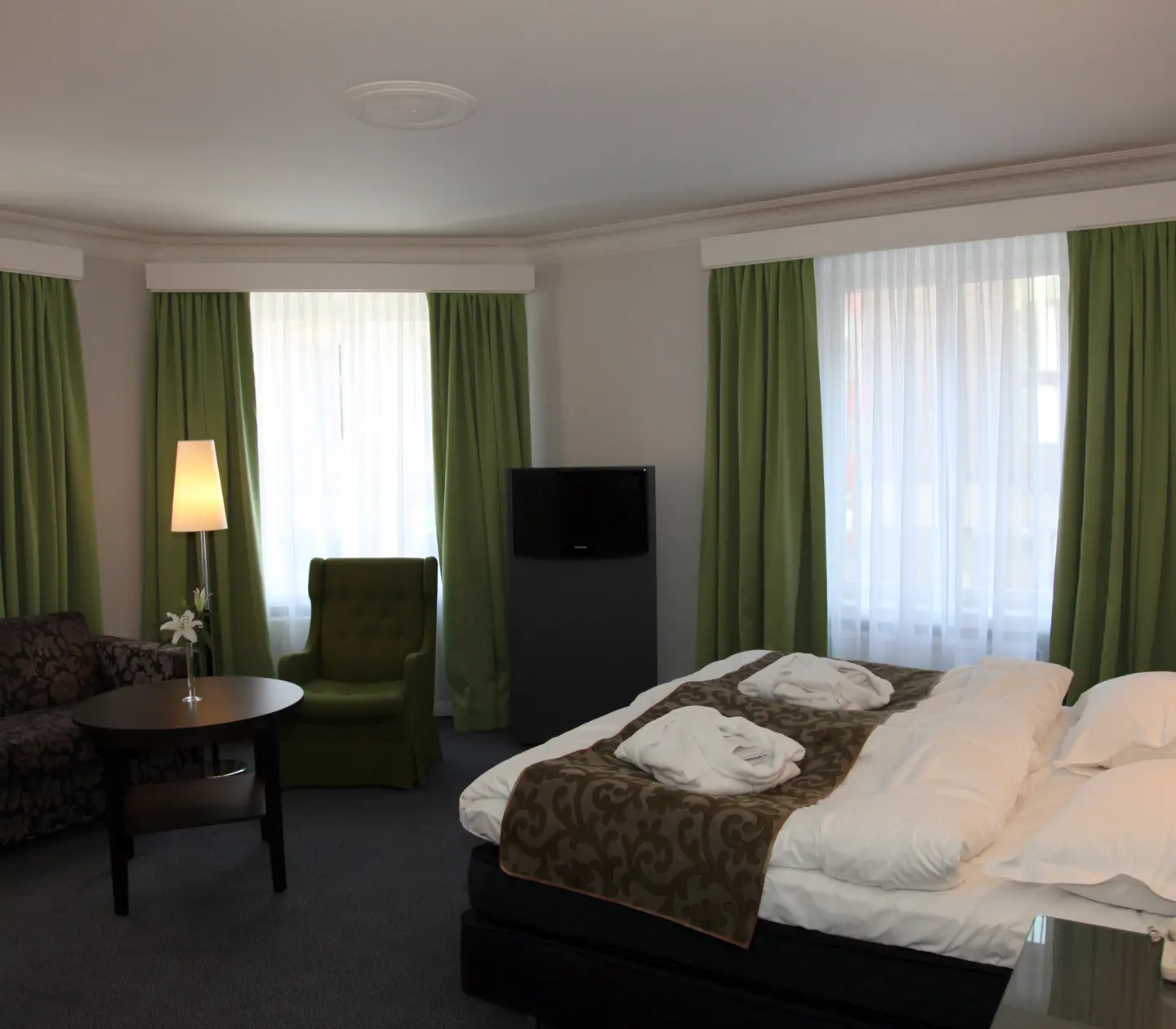 Bright hotel room with bed, sofa and large windows