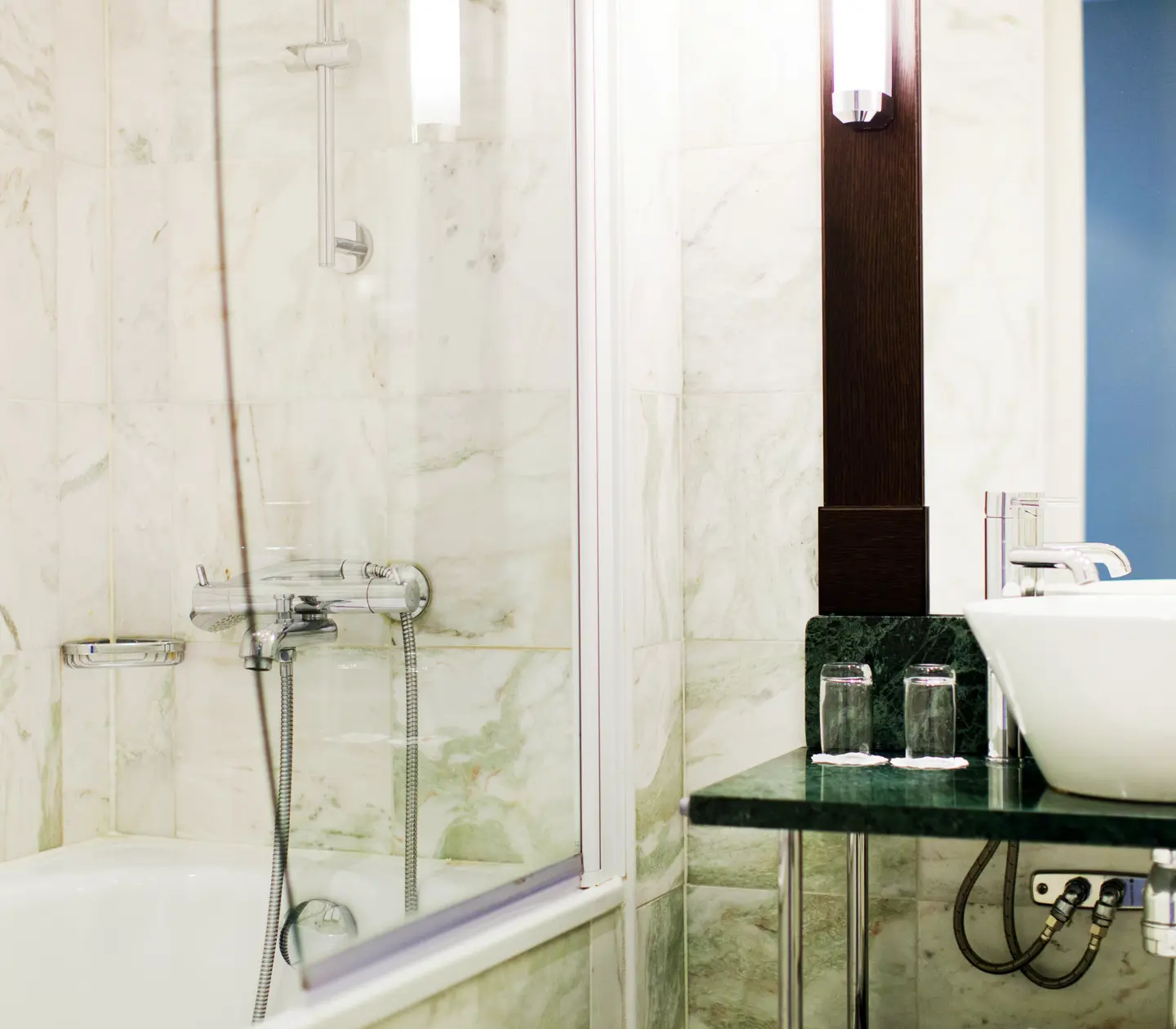 Bright bathroom with bathtub, green sink and mirror