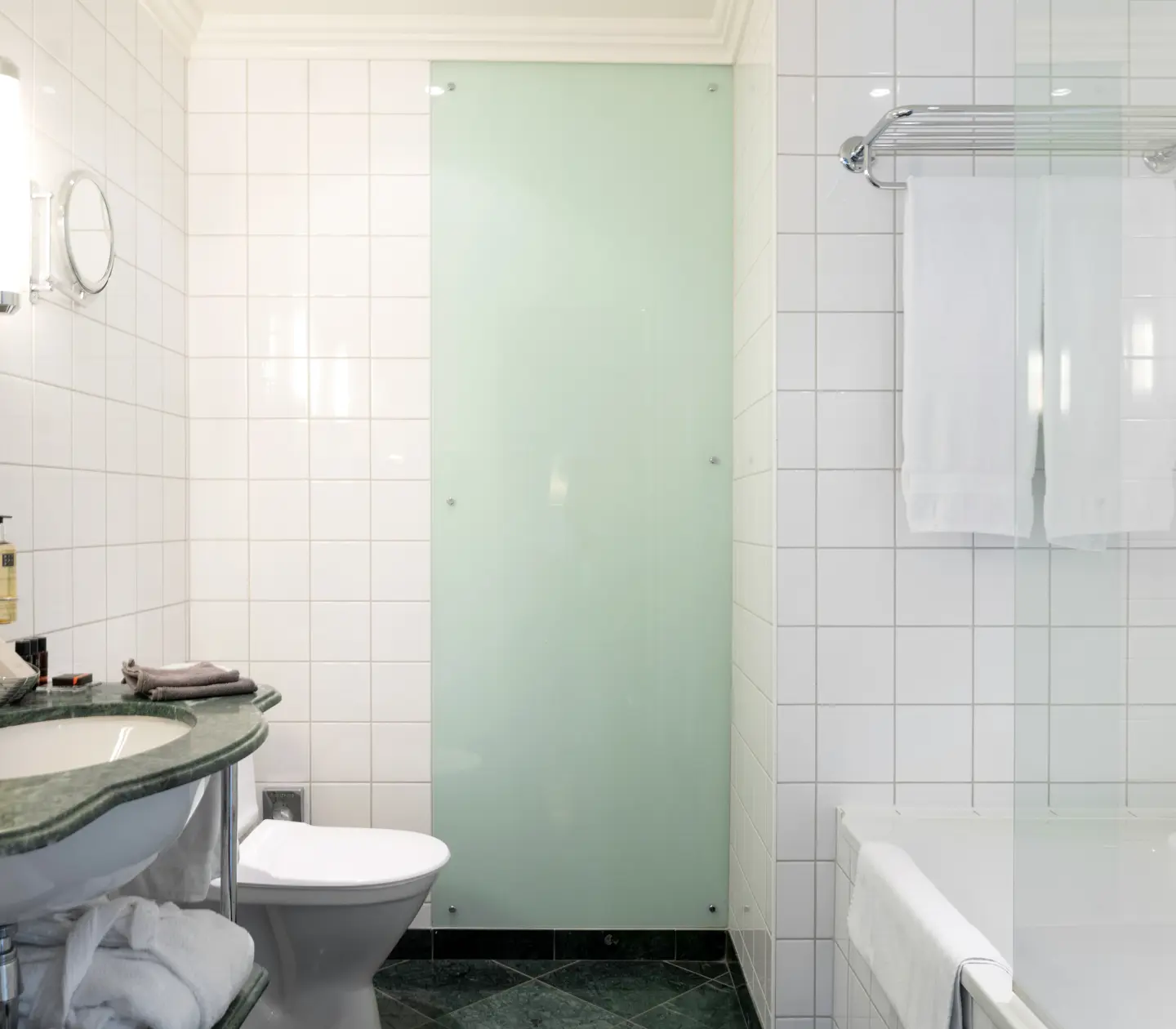 Bright bathroom with bathtub, green sink and toilet