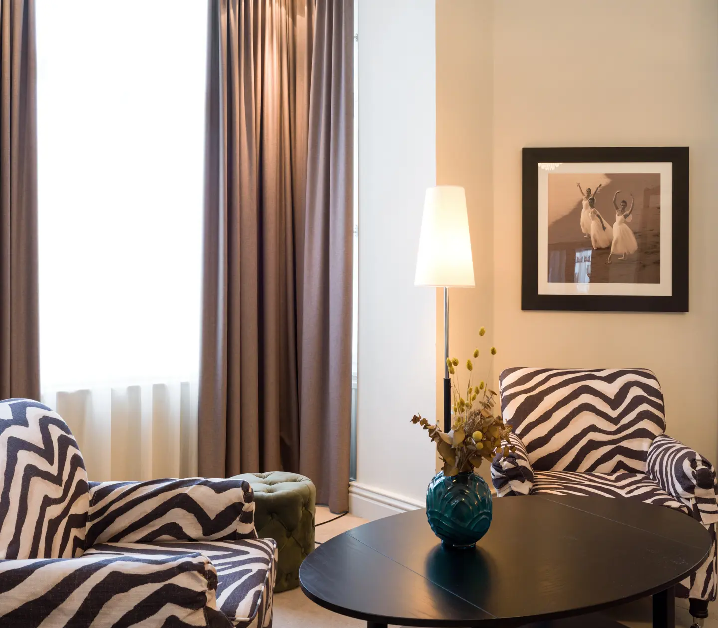 Bright suite with zebra-patterned armchairs, window and painting