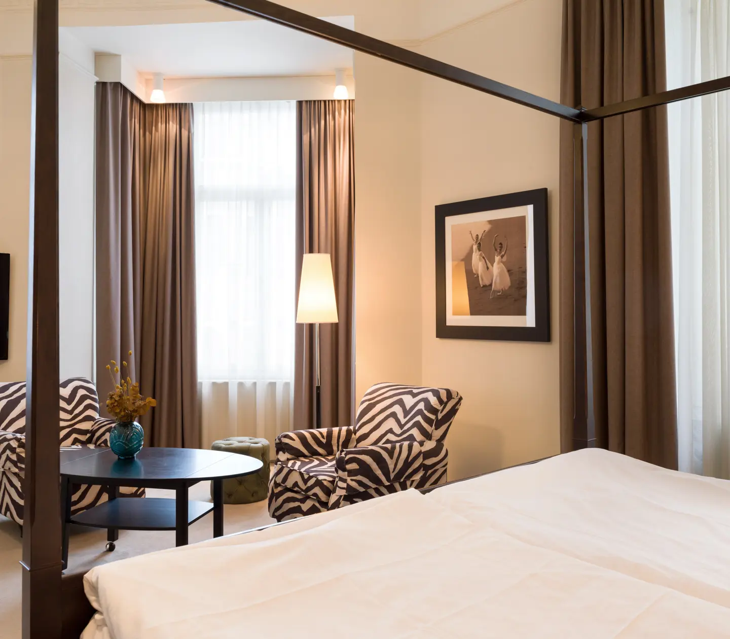 Bright suite with zebra-patterned armchairs, bed and window