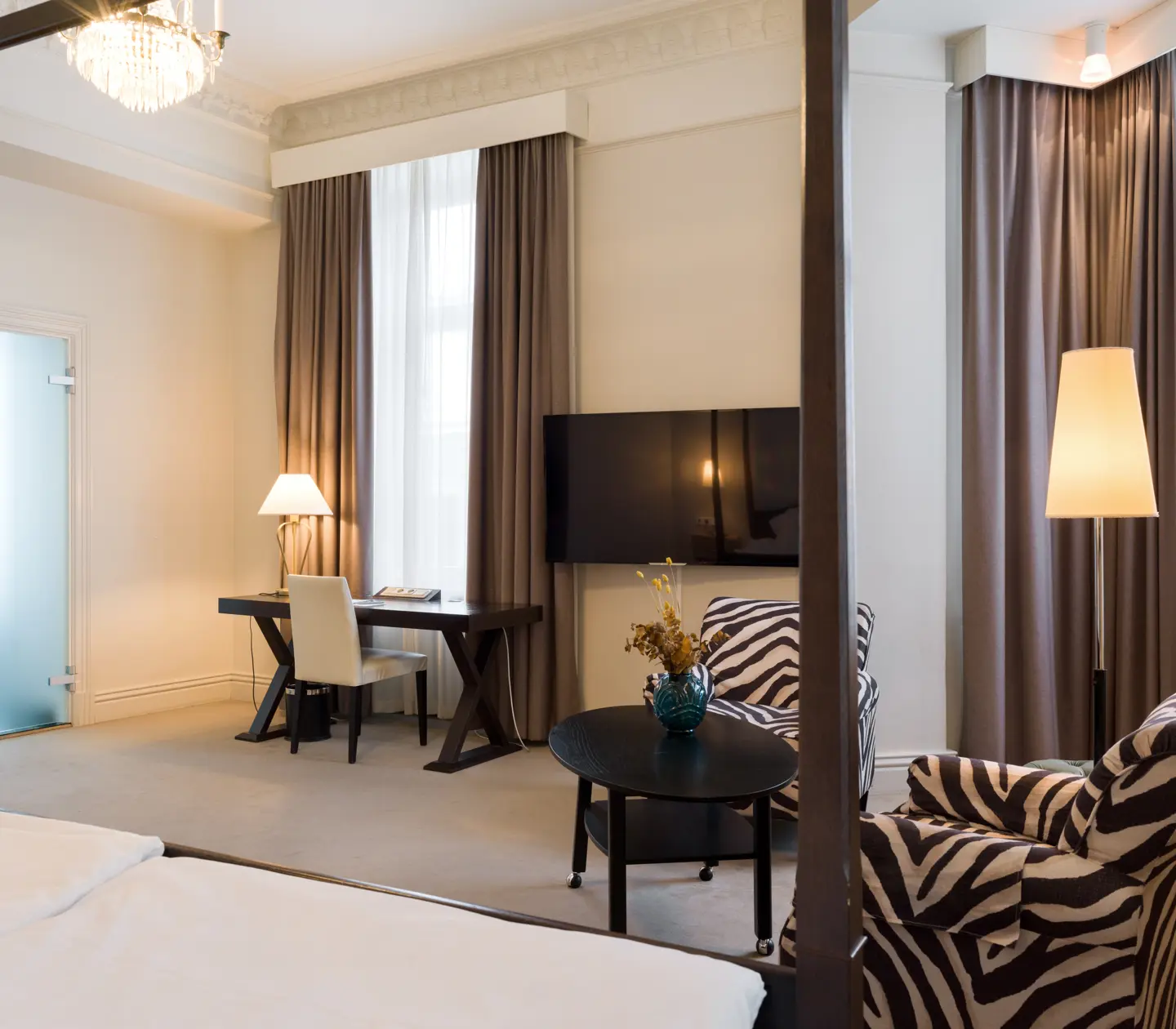 Bright suite with zebra-patterned armchairs, desk and TV