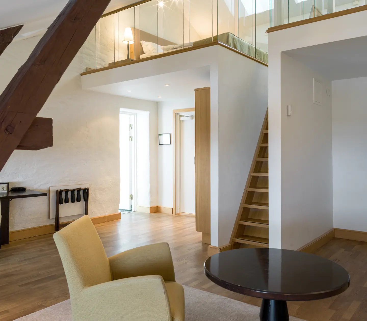Bright suite with wooden beams from the ceiling, stairs and sleeping loft