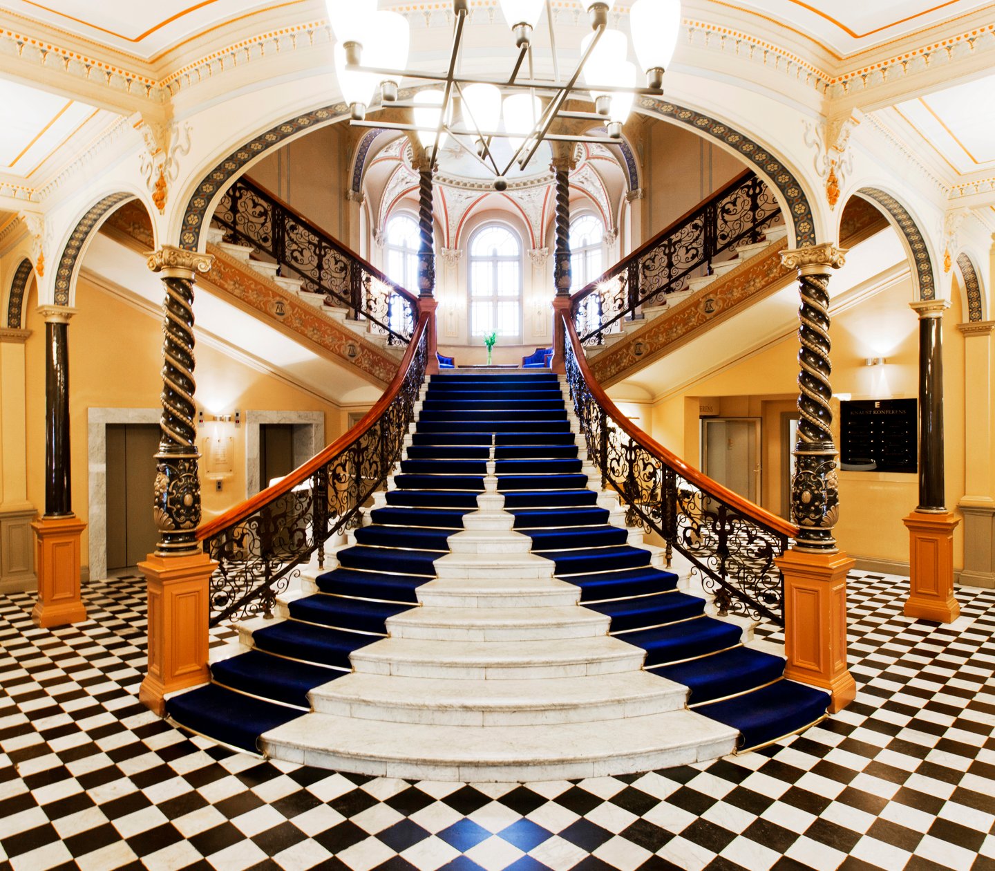 Pampiga trappa med mycket dekorationer i hotellobby med schackrutigt golv