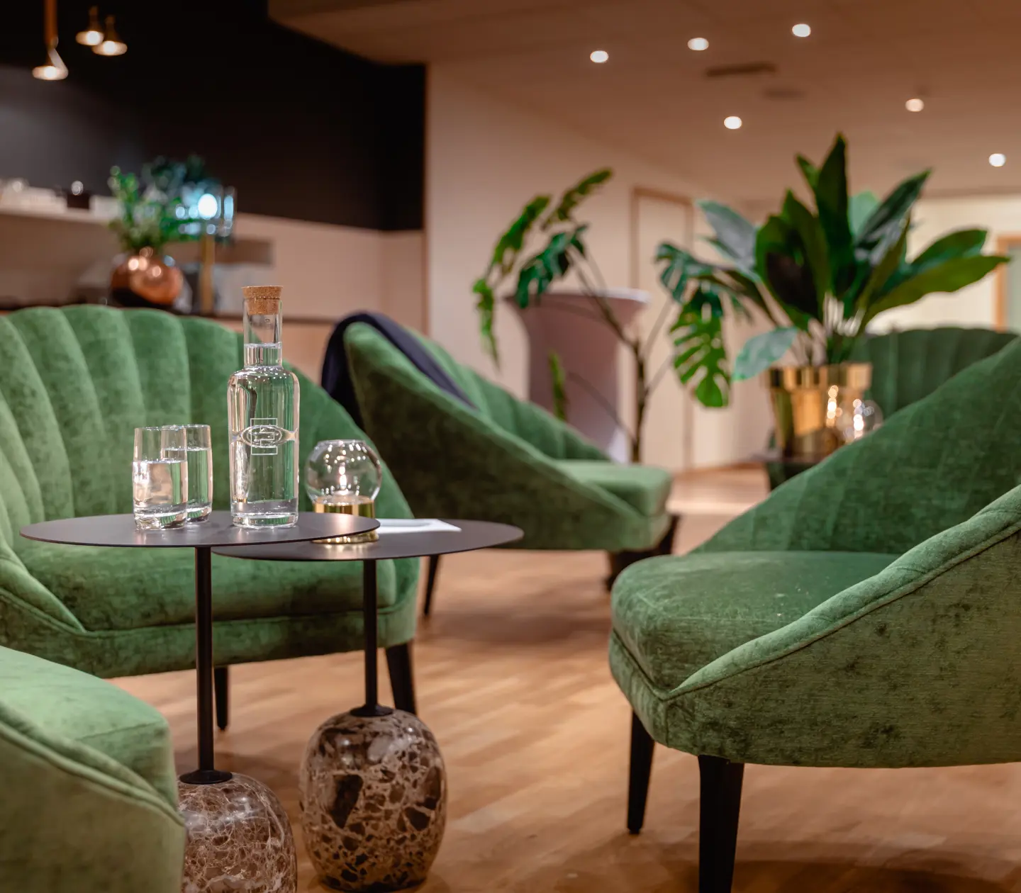 Conference environment with green armchairs, water glasses and plants