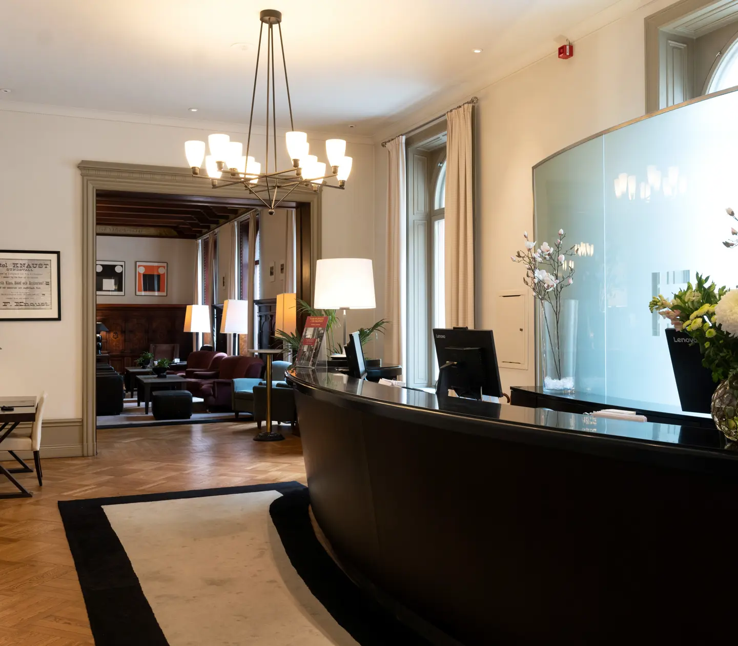 Hotel lobby with reception desk, lounge furniture and flower bouquet