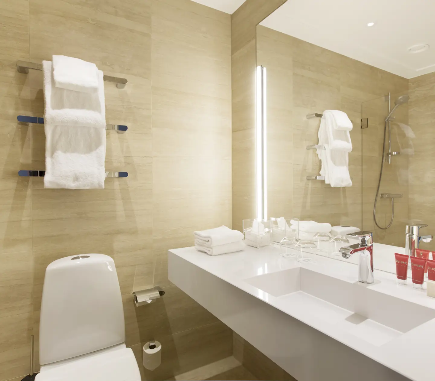 Beige bathroom with toilet, sink and mirror