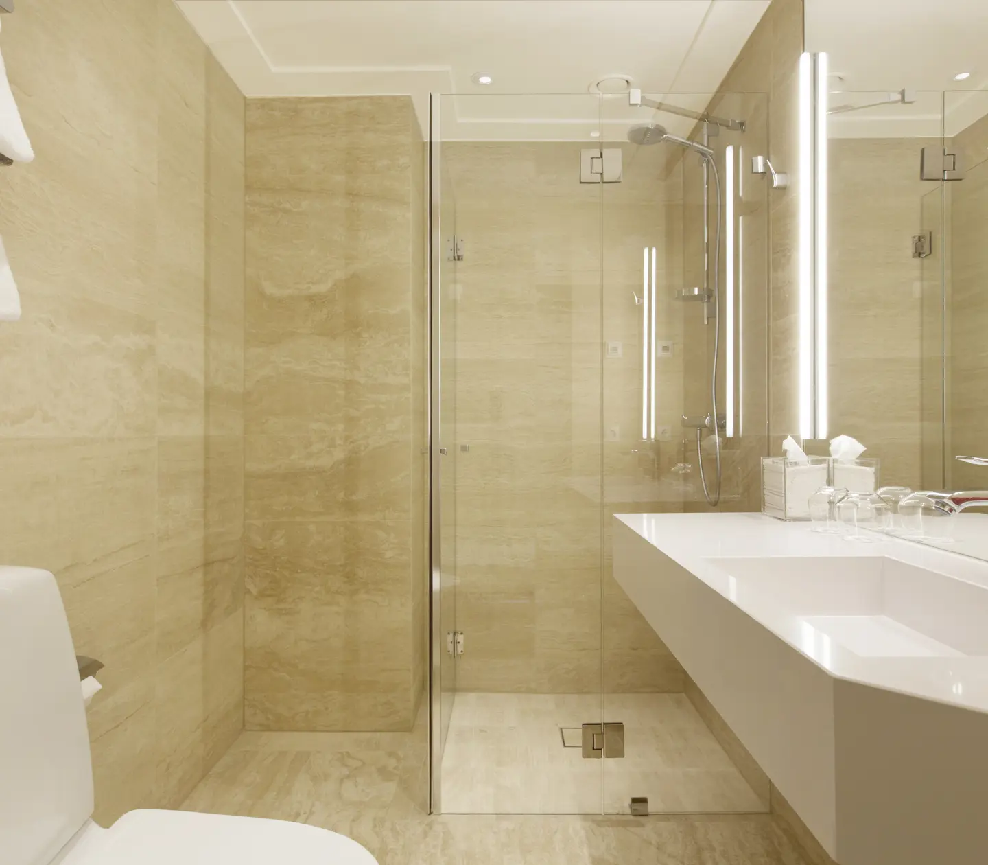 Beige bathroom with toilet, sink and mirror