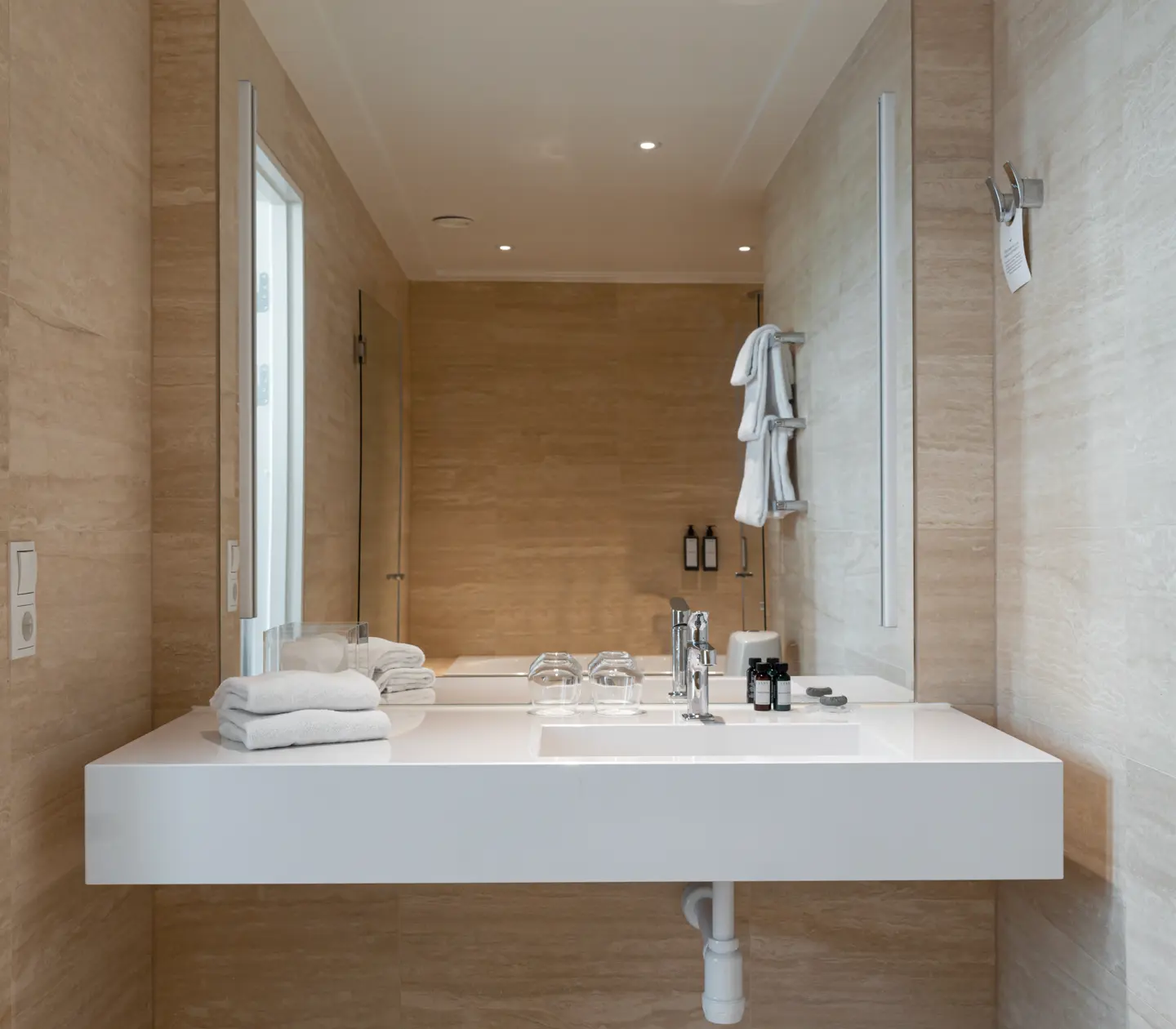 Beige bathroom with shower, sink and mirror