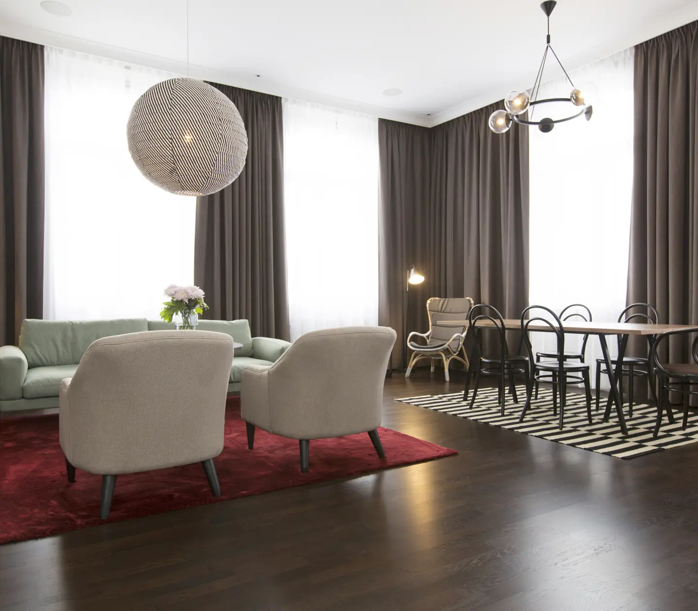 Bright suite with large windows, dining area and sofa area