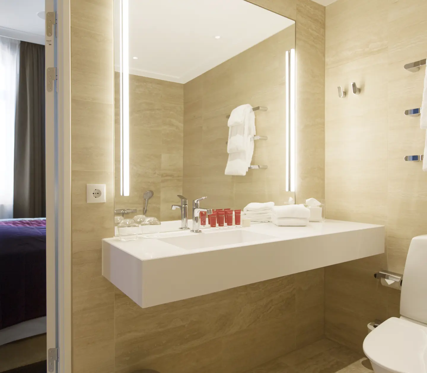 Beige bathroom with toilet, sink and mirror