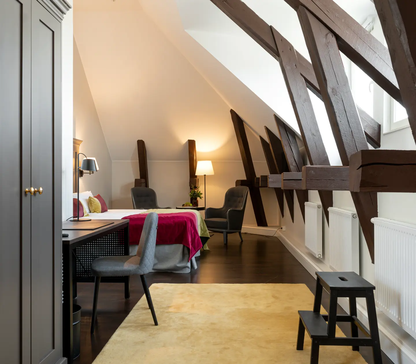Bright suite with bed, wooden beams and desk