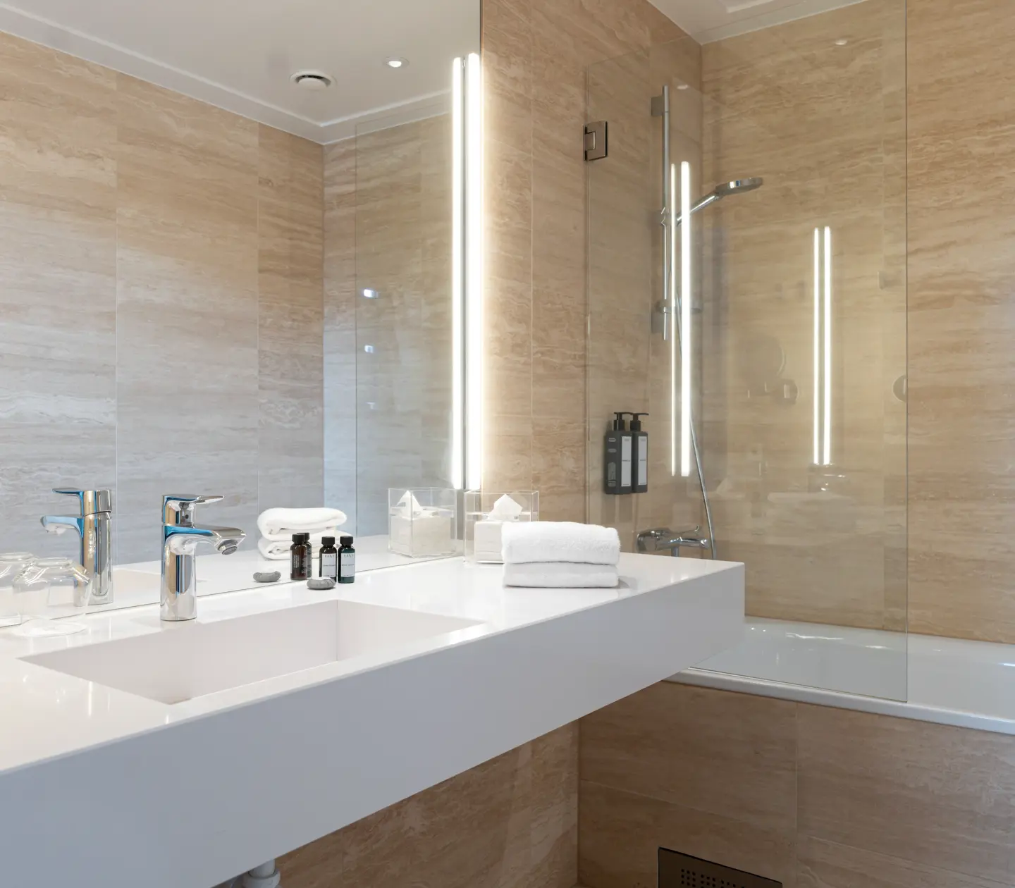 Beige bathroom with bathtub, sink and mirror