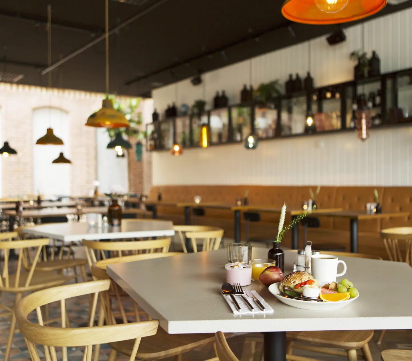 Restaurant environment with breakfast served on tables and dining groups in the background