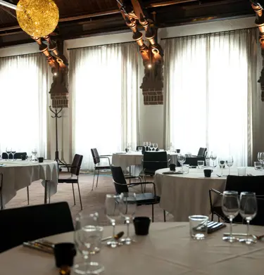 Dining room with many windows, decorations and set round tables