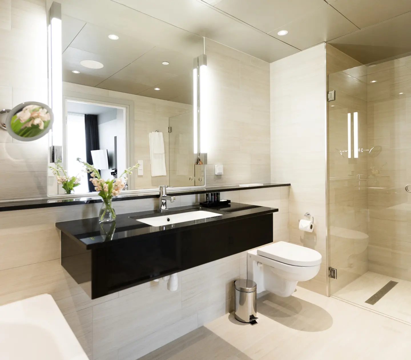 Beige bathroom with toilet, shower and black sink