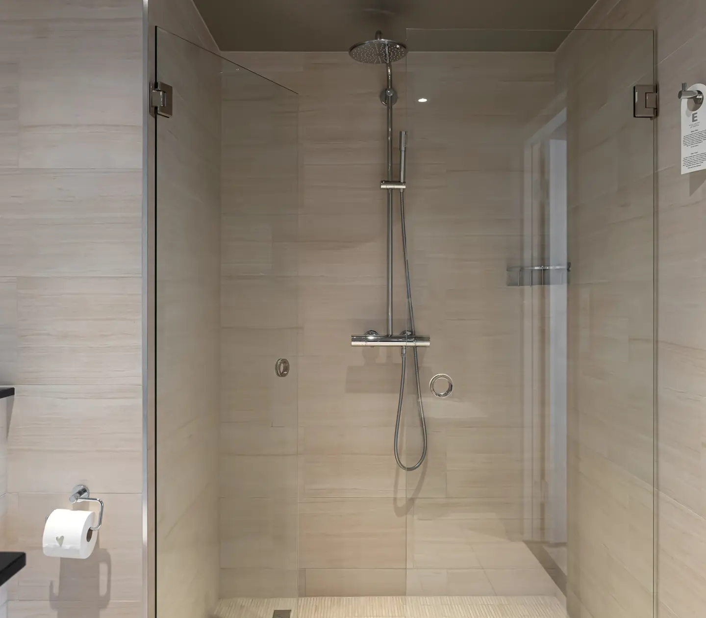 Beige bathroom with shower, flower and towels