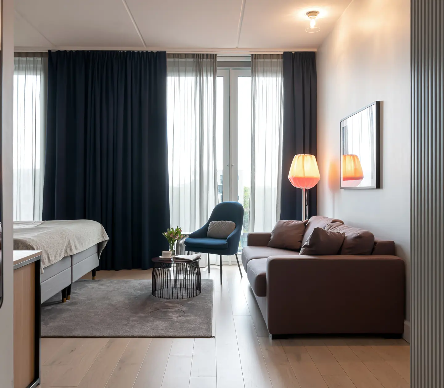Cozy suite with bed, sofa and large windows