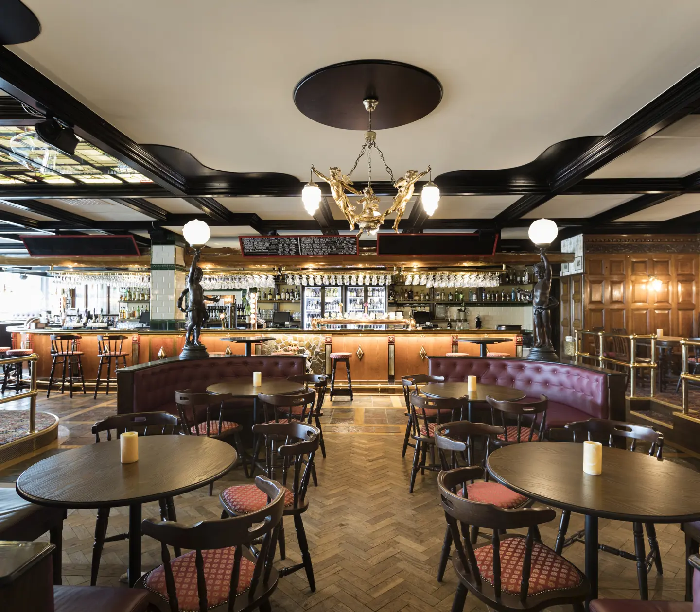 Pub environment with round tables, bar and ceiling decorations