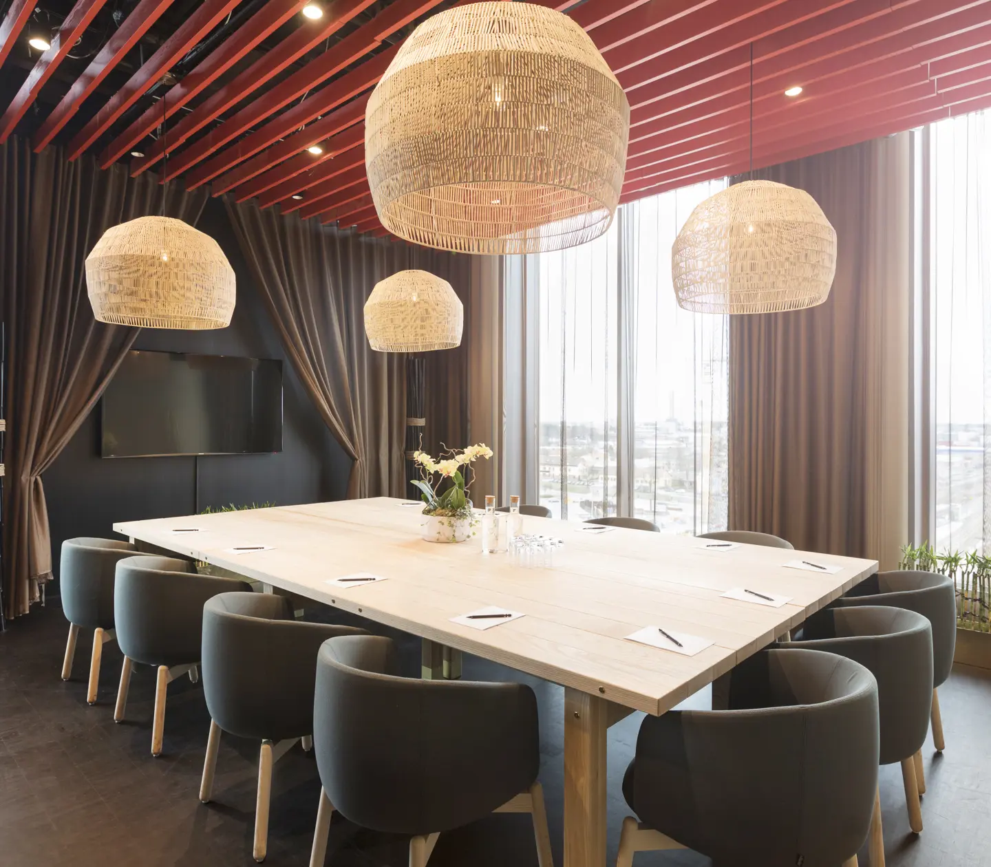 Conference room with large table, ceiling lights and large windows